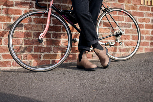 A persons legs and a bicycle.