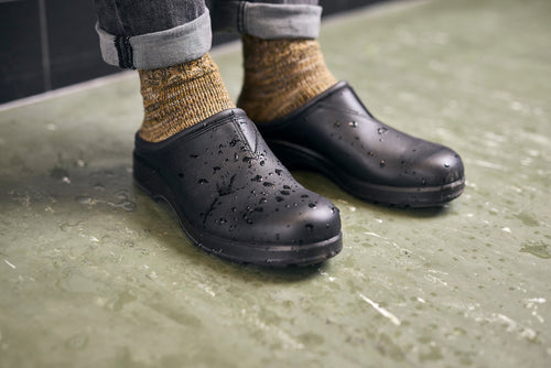 A pair of feet wearing black shoes.