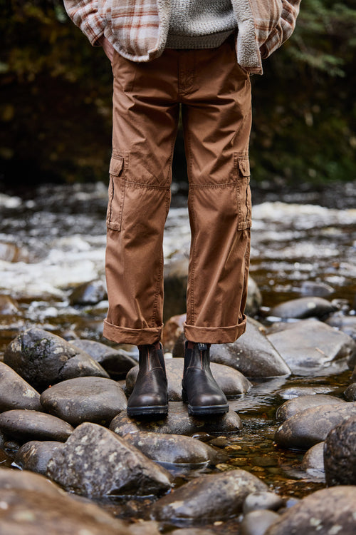 A person standing on rocks in water.