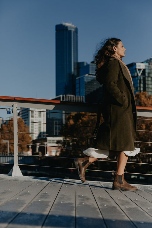 A woman walking on a bridge.