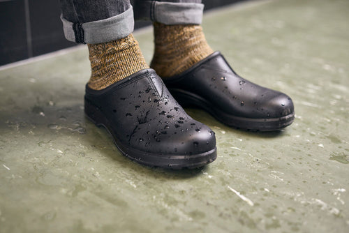 A pair of feet wearing black shoes.