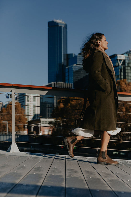 A woman walking on a bridge.